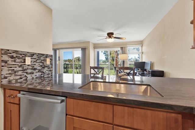 kitchen with ceiling fan, dishwasher, sink, and decorative backsplash