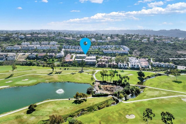 birds eye view of property with golf course view and a water view