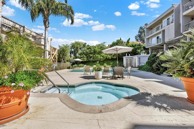 community pool with a community hot tub and a patio area