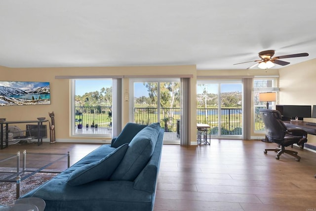 living room featuring wood finished floors, ceiling fan, and baseboards