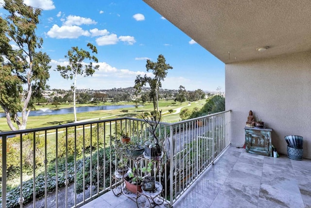 balcony featuring view of golf course and a water view
