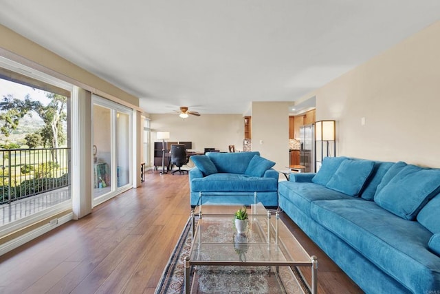 living area with ceiling fan, wood-type flooring, and baseboards