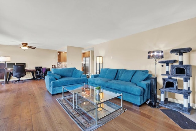 living room with wood-type flooring, ceiling fan, and baseboards