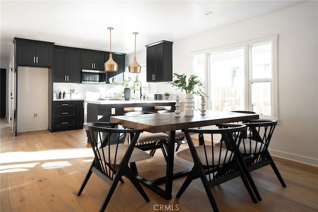 dining room with sink and light wood-type flooring