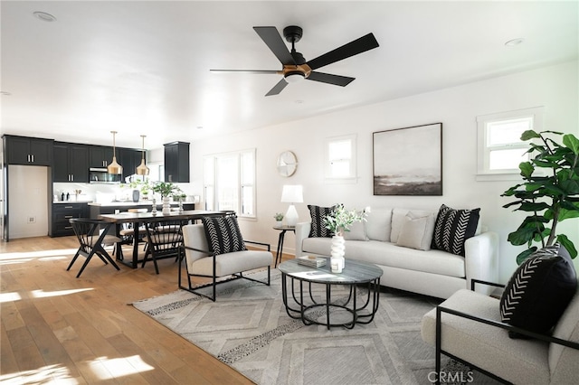 living room with light hardwood / wood-style floors and ceiling fan