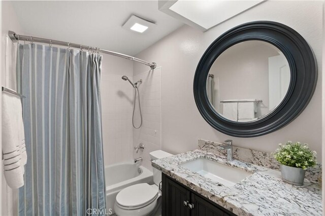 full bathroom with vanity, shower / bath combination with curtain, and toilet