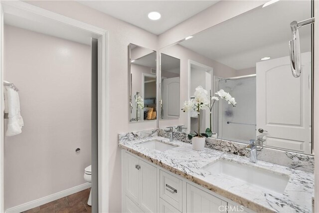 bathroom featuring walk in shower, vanity, and toilet