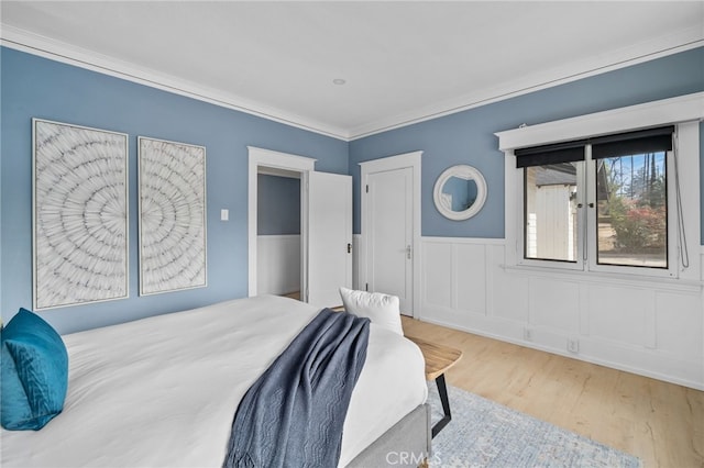 bedroom featuring crown molding and light wood-type flooring