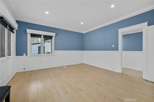 spare room with ornamental molding and light hardwood / wood-style floors