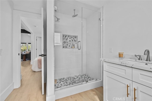 bathroom featuring walk in shower, vanity, and hardwood / wood-style floors