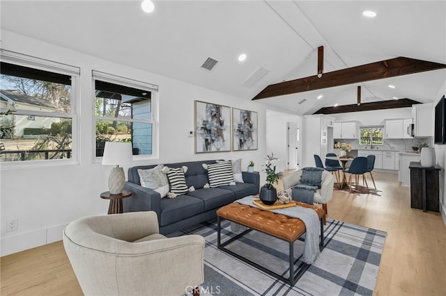 living room with lofted ceiling with beams and light wood-type flooring