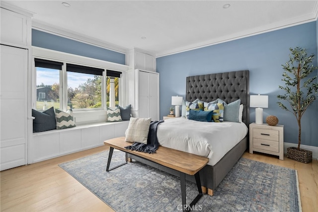 bedroom with ornamental molding and light hardwood / wood-style floors