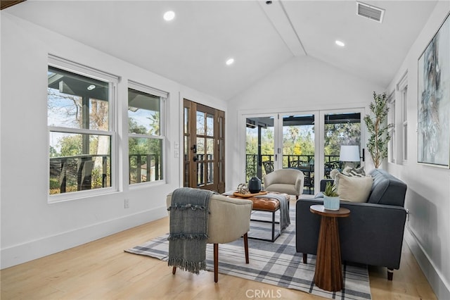 living room featuring vaulted ceiling and light hardwood / wood-style floors