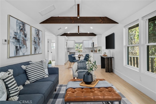 living room featuring lofted ceiling with beams and light hardwood / wood-style flooring