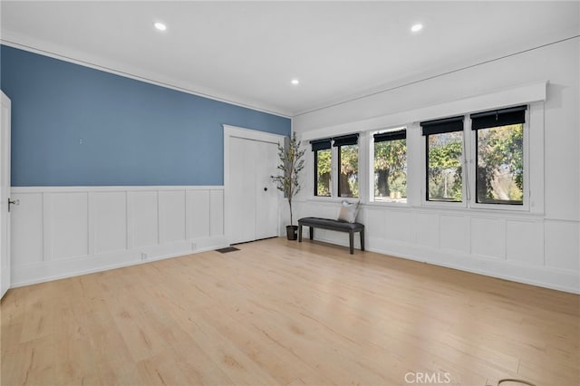 unfurnished room featuring ornamental molding and light wood-type flooring