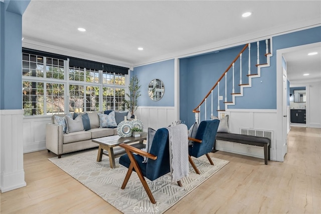 living room featuring crown molding and light hardwood / wood-style flooring