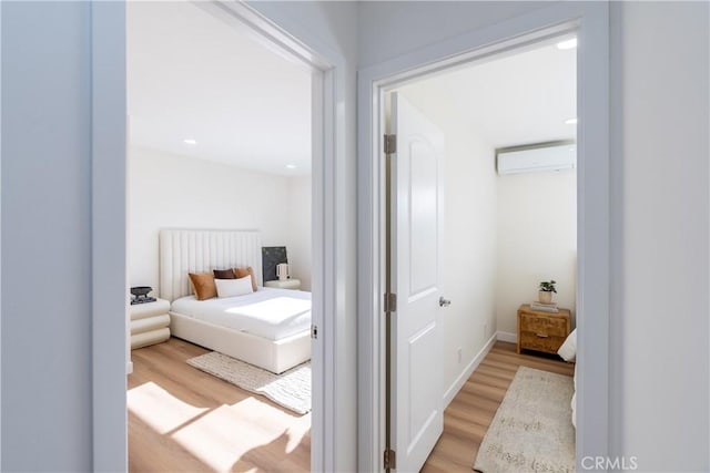 bedroom featuring radiator heating unit, a wall unit AC, and light hardwood / wood-style flooring