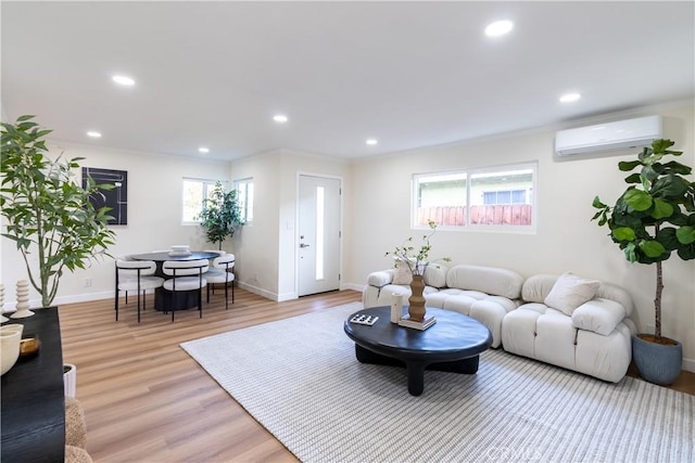 living room with light hardwood / wood-style floors and an AC wall unit