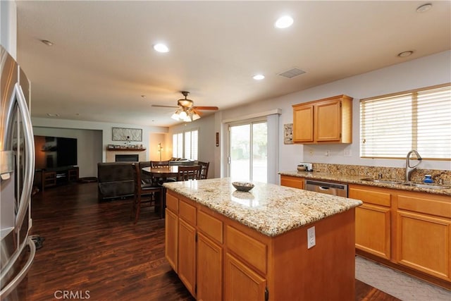 kitchen featuring sink, ceiling fan, appliances with stainless steel finishes, dark hardwood / wood-style floors, and a center island