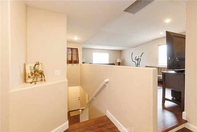 stairway with lofted ceiling and hardwood / wood-style floors