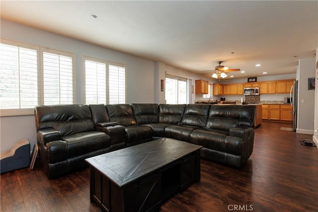 living room with dark wood-type flooring and ceiling fan