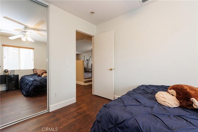 bedroom with dark hardwood / wood-style flooring, a closet, and ceiling fan