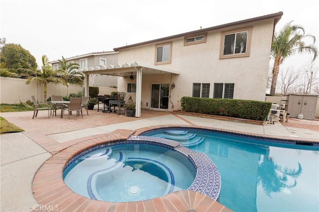 back of property with a swimming pool with hot tub and a patio