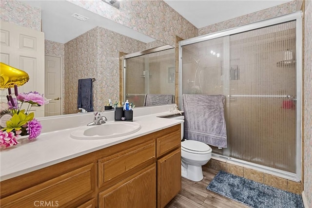 bathroom featuring vanity, toilet, an enclosed shower, and wood-type flooring