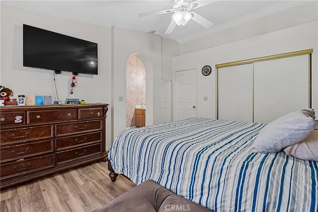 bedroom with ceiling fan, light hardwood / wood-style floors, and a closet