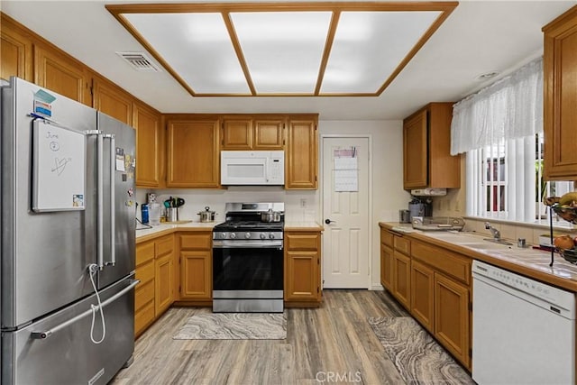 kitchen featuring hardwood / wood-style flooring, appliances with stainless steel finishes, and sink