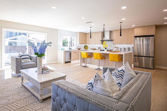 living room featuring sink and light hardwood / wood-style flooring