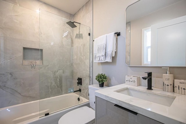 full bathroom with tiled shower / bath, vanity, and toilet