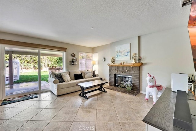 living room featuring a fireplace, a textured ceiling, and light tile patterned floors