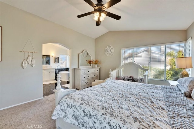 bedroom with lofted ceiling, ensuite bath, light colored carpet, and ceiling fan