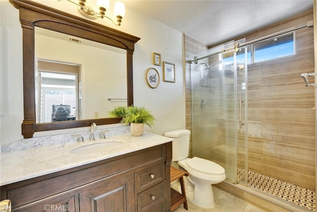 bathroom featuring vanity, toilet, tile patterned flooring, and a shower with door