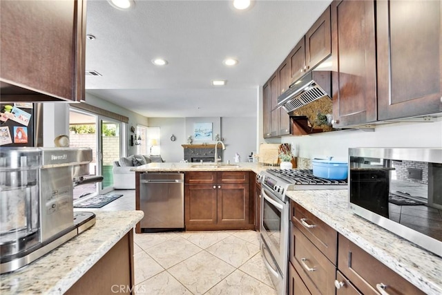 kitchen featuring appliances with stainless steel finishes and light stone counters