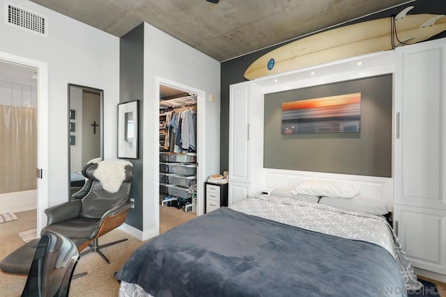 bedroom featuring light colored carpet, a spacious closet, and a closet