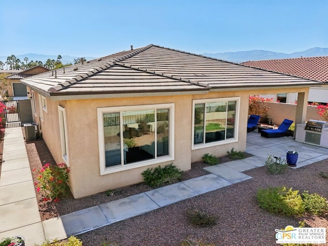 exterior space featuring central AC, a mountain view, and a patio