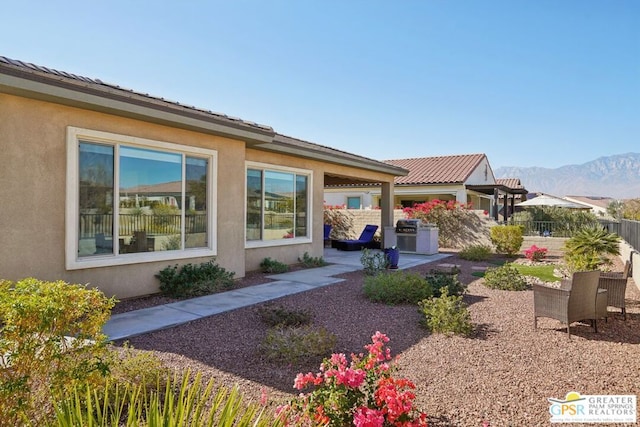 view of side of property featuring a mountain view and a patio