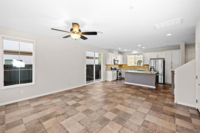 unfurnished living room with ceiling fan