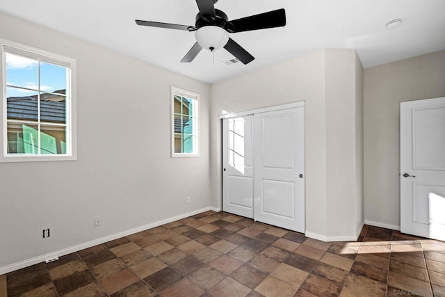 unfurnished bedroom featuring multiple windows, a closet, and ceiling fan