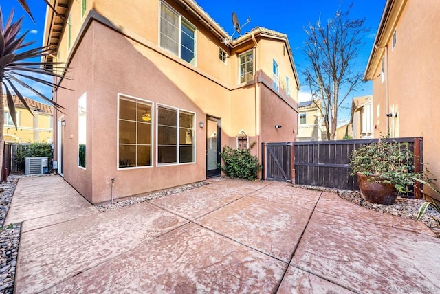 back of property with cooling unit and a patio area