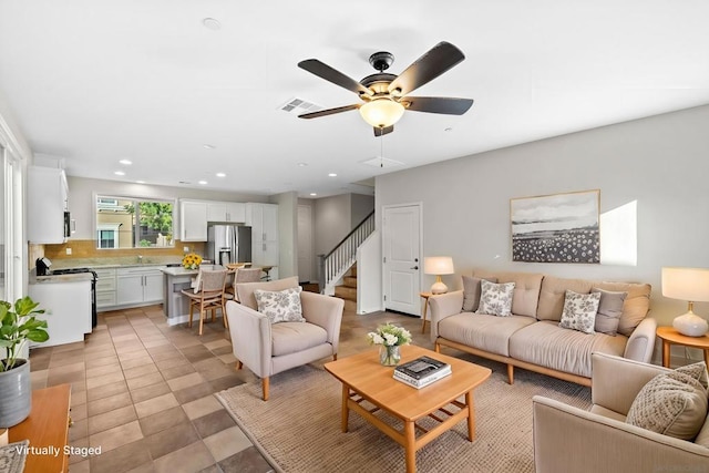 tiled living room with ceiling fan and sink