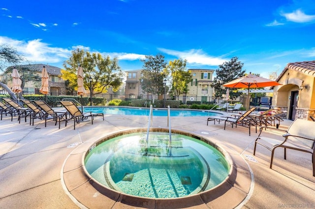 view of swimming pool featuring a community hot tub and a patio area