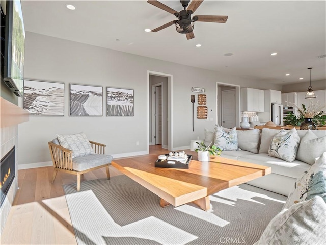 living room featuring ceiling fan and light hardwood / wood-style floors