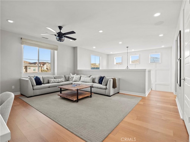 living room with ceiling fan, a healthy amount of sunlight, and light hardwood / wood-style floors