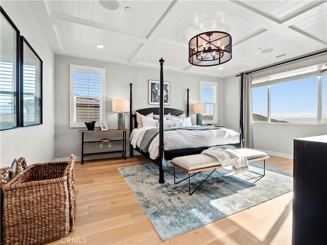 bedroom featuring beam ceiling, coffered ceiling, a chandelier, and light hardwood / wood-style flooring