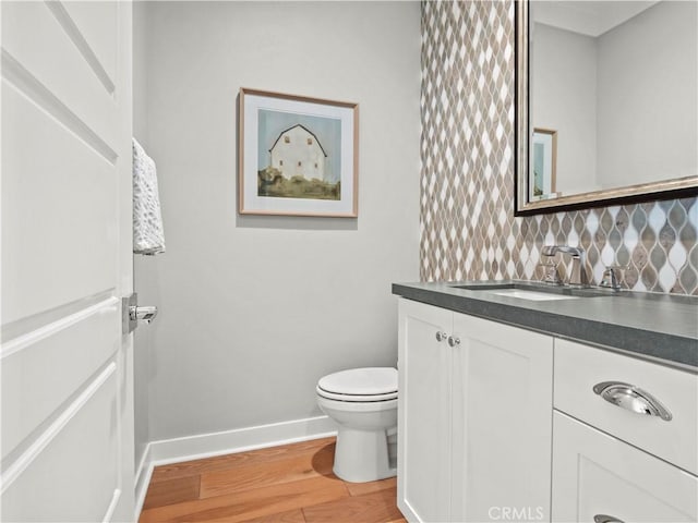 bathroom with hardwood / wood-style flooring, tasteful backsplash, vanity, and toilet