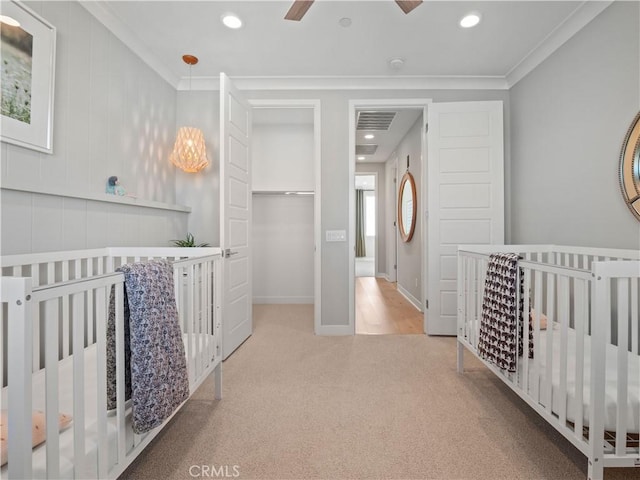 carpeted bedroom featuring ceiling fan, ornamental molding, and a closet