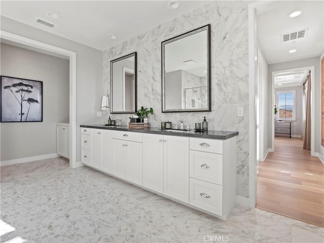 bathroom with vanity and tile walls